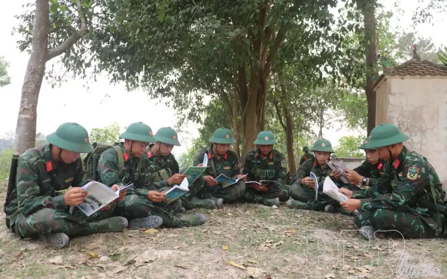 Chiến sĩ tranh thủ đọc sách, báo trong giờ nghỉ trên thao trường